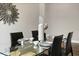 Bright dining room features a modern glass table, wood-look flooring, and contemporary decor at 1057 Sugarloaf Key Loop, Lady Lake, FL 32159