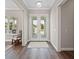 Inviting entryway with double glass doors and wood floors that leads to the bright home interior at 1057 Sugarloaf Key Loop, Lady Lake, FL 32159