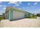 Exterior view of a light teal home with a paved driveway and an attached garage at 1057 Sugarloaf Key Loop, Lady Lake, FL 32159