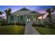 Charming coastal-style home featuring a welcoming front porch, lush landscaping, and a well-manicured lawn at 1057 Sugarloaf Key Loop, Lady Lake, FL 32159