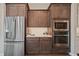 Stainless steel kitchen appliances, including a refrigerator, microwave, and oven, blend with cabinetry at 1057 Sugarloaf Key Loop, Lady Lake, FL 32159
