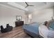 Comfortable main bedroom featuring tray ceilings, wood-look floors, a dark wood dresser and a cozy armchair at 1057 Sugarloaf Key Loop, Lady Lake, FL 32159