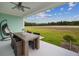 Outdoor patio features ceiling fan, dining table, hanging chair and views of the green landscape at 1057 Sugarloaf Key Loop, Lady Lake, FL 32159