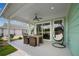 Covered patio with ceiling fan, dining table, and hanging chair for relaxing outdoor living at 1057 Sugarloaf Key Loop, Lady Lake, FL 32159