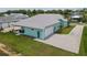 This aerial view showcases a home with a patio, 2-car garage and a well-maintained lawn at 1057 Sugarloaf Key Loop, Lady Lake, FL 32159