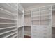 Spacious walk-in closet features custom shelving, drawers, and ample storage space for organization at 1057 Sugarloaf Key Loop, Lady Lake, FL 32159
