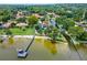 Aerial view of home on the lake with beach, boat dock, and beautiful trees at 112 Waterwood Dr, Yalaha, FL 34797