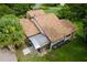 Aerial view of the home showcasing its roof, screened in patio, and lush yard at 112 Waterwood Dr, Yalaha, FL 34797