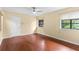 This bedroom features wood floors, two windows, and a ceiling fan at 112 Waterwood Dr, Yalaha, FL 34797