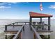 Waterfront view from a private dock featuring a covered sitting area, ideal for outdoor relaxation and entertainment at 112 Waterwood Dr, Yalaha, FL 34797