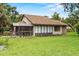 View of a single story home, showing a screened in porch and well-maintained lawn at 112 Waterwood Dr, Yalaha, FL 34797