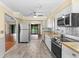 Open kitchen with stainless steel appliances, wood countertops, view to the screened-in porch at 112 Waterwood Dr, Yalaha, FL 34797