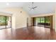 Spacious living room features shiny hard wood floors, a ceiling fan, and sliders to the lanai at 112 Waterwood Dr, Yalaha, FL 34797