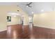 Spacious living room with hard wood floors, a ceiling fan, and a view of the kitchen at 112 Waterwood Dr, Yalaha, FL 34797