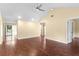 Large, empty living room featuring hard wood floors, a ceiling fan, and large windows at 112 Waterwood Dr, Yalaha, FL 34797