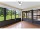Bright sunroom featuring hardwood flooring, large windows with lovely backyard views at 112 Waterwood Dr, Yalaha, FL 34797