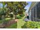 Lush backyard featuring mature trees and a view of the screened-in patio at 1122 Magrath Way, The Villages, FL 32162