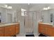 Bathroom featuring double vanity sinks and a glass-enclosed shower at 1122 Magrath Way, The Villages, FL 32162