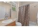 Bright bathroom featuring a shower-tub combination, decorative shower curtain and granite vanity at 1122 Magrath Way, The Villages, FL 32162