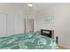 Comfortable bedroom with a tropical-themed bedspread and closet space at 1122 Magrath Way, The Villages, FL 32162