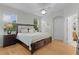 Bright main bedroom featuring a large bed, a ceiling fan, and natural light at 1122 Magrath Way, The Villages, FL 32162
