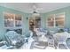 Beautiful sunroom with stylish wicker furniture, ample seating, and a glass top table at 1122 Magrath Way, The Villages, FL 32162