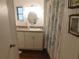 Bathroom features single vanity, light fixtures, and a shower curtain at 114 Azalea Trl, Leesburg, FL 34748