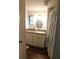 Bathroom features single vanity, light fixtures, and a shower curtain at 114 Azalea Trl, Leesburg, FL 34748