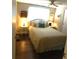 Comfortable bedroom with wicker headboard, lovely beside tables, decor, and wood-look flooring at 114 Azalea Trl, Leesburg, FL 34748