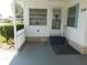 Inviting entrance featuring a covered patio, white picket fence, and well maintained landscaping at 114 Azalea Trl, Leesburg, FL 34748