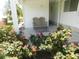 Welcoming front porch area, framed by lush rose bushes and featuring cozy outdoor seating at 114 Azalea Trl, Leesburg, FL 34748