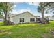 Exterior view of a home with a patio and well-maintained lawn at 1214 Loch Rannoch Ct, Leesburg, FL 34788