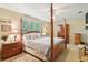 Bedroom with four poster bed, neutral walls and carpet, and ceiling fan at 1214 Loch Rannoch Ct, Leesburg, FL 34788