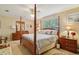 Traditional style bedroom with four poster bed, ceiling fan, and wooden furniture at 1214 Loch Rannoch Ct, Leesburg, FL 34788
