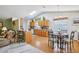 Open-concept kitchen with hardwood floors, wood cabinets, breakfast bar, and adjacent dining space at 1214 Loch Rannoch Ct, Leesburg, FL 34788
