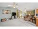 Spacious living room with carpet, ceiling fans, and a seamless flow to the kitchen at 1214 Loch Rannoch Ct, Leesburg, FL 34788