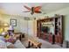 Living room with ceiling fan, wood entertainment center, sofa, and white closet doors at 1214 Loch Rannoch Ct, Leesburg, FL 34788
