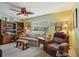 Cozy living room with ceiling fan, desk, sofa, recliner, and built-in bookshelves at 1214 Loch Rannoch Ct, Leesburg, FL 34788