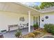 Inviting covered porch with decorative seating, lush potted plants, and a welcoming entryway at 1214 Loch Rannoch Ct, Leesburg, FL 34788