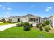 Charming single-story home featuring a well-manicured lawn, white picket fence, and screened porch at 1225 Eunice St, The Villages, FL 34762
