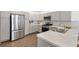 Well-lit kitchen showcases stainless steel appliances, grey cabinets, and updated countertops at 1225 Eunice St, The Villages, FL 34762