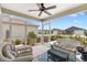 Inviting screened lanai with a ceiling fan, comfortable seating, and peaceful neighborhood views at 1225 Eunice St, The Villages, FL 34762