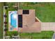 Aerial view of a house with solar panels, a large backyard with a pool, spa and manicured landscaping at 1414 Cove Pl, Tavares, FL 32778