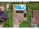 Aerial view of a house with solar panels, a large backyard with a pool, spa and manicured landscaping at 1414 Cove Pl, Tavares, FL 32778