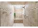 Bright bathroom boasts tile shower with bench and skylight for ample natural light at 1414 Cove Pl, Tavares, FL 32778