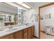 Bright bathroom with double sinks, a large mirror, and stylish coastal decor at 1414 Cove Pl, Tavares, FL 32778
