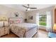Light-filled bedroom features a ceiling fan, wood floors and a view to the backyard at 1414 Cove Pl, Tavares, FL 32778