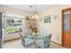 Cozy breakfast nook with glass top table, floral chairs, and bright window overlooking landscape at 1414 Cove Pl, Tavares, FL 32778