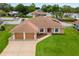 Charming single-story home featuring a two-car garage, manicured lawn, and lovely landscaping at 1414 Cove Pl, Tavares, FL 32778