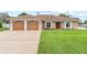 Attractive single-story home with a two-car garage, spacious driveway, and lush green lawn at 1414 Cove Pl, Tavares, FL 32778
